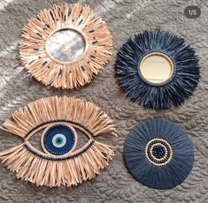 three decorative mirrors with blue and gold accents on a gray surface, one has an evil eye in the middle