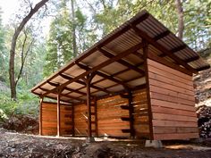 a wooden structure in the woods with lots of trees