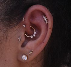 a close up of a person's ear with three different piercings on it