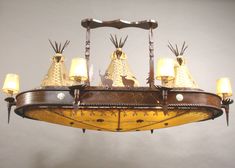 a chandelier with five lamps hanging from it's sides and two deer heads on the top