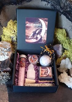 a box filled with lots of different items on top of a table next to rocks