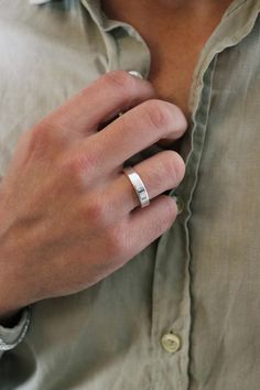 a man wearing a silver ring on his left hand