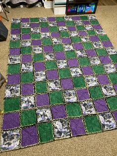 a green, purple and white rug on the floor