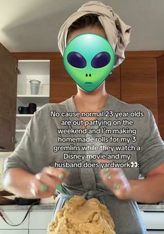 a woman with an alien mask on her head holding a cookie in front of her face