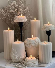 white candles with flowers and pearls on them