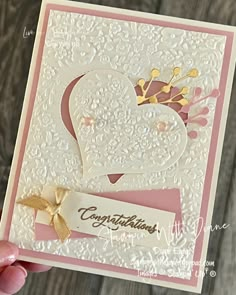 someone is holding up a card that has a heart and crown on it, with the word congratulations written in gold