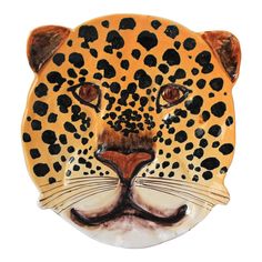 a ceramic leopard head with black spots on it's face and brown nose, against a white background