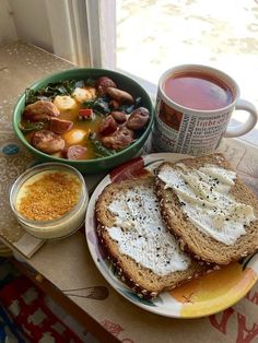 a table topped with a bowl of soup and two plates filled with food