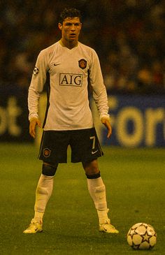 a man standing next to a soccer ball on a field