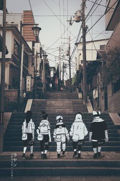 three children are walking down the stairs in front of some buildings and power lines above them