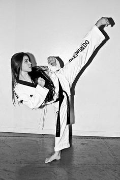 a woman is doing karate in a black and white photo