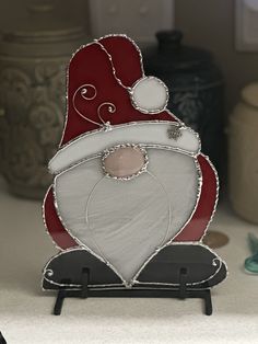 a santa clause is sitting on top of a shelf in front of some other items