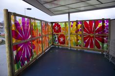 an outdoor area with colorful artwork on the wall and flooring in front of it