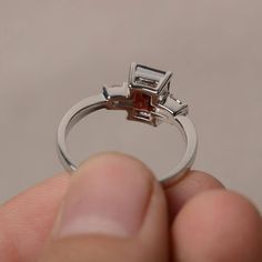 This is a gorgeous handmade creation. Its beauty is its simplicity & Elegance. The 6*8 mm emerald shape faceted natural garnet is crafted in solid sterling silver and with rhodium plated. All item is sent in a beautiful gift box If you have any idea of design your ring,pls contact me directly. You can realize more lovely stuff clicking the link https://www.etsy.com/shop/knightjewelry?refshopsection_shophome_leftnav Please leave the correct address and you phone number for delivering successf Emerald Cut Sapphire Ring For Proposal, Emerald Cut Ruby Ring Gift, Wedding Rings With Baguette Cut Tourmaline, Baguette Cut Tourmaline Wedding Ring, Garnet Emerald Cut Promise Ring, Gift Ruby Ring With Radiant Cut, Emerald Cut Ruby Ring With Accent Stones As Gift, Emerald Cut Garnet Promise Ring, Emerald Cut Garnet Rings For Gift