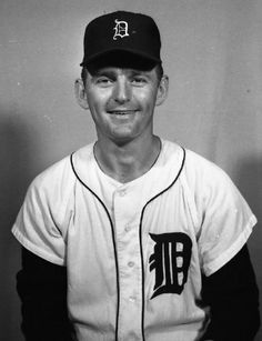 a black and white photo of a man wearing a baseball uniform with the detroit tigers on it