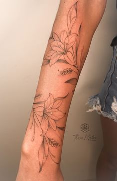 a woman's leg with flowers on it and the bottom part of her arm