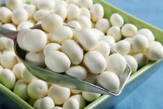 there is a spoon full of white beans on the green plate and blue tablecloth