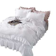 a white bed with ruffled sheets and pillows