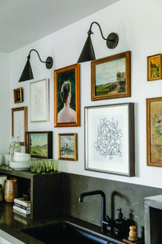 a kitchen with pictures hanging on the wall