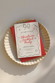 a paper plate with a christmas card on it next to a red and white envelope