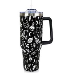 a black and white travel mug with cats, stars, and other things on it