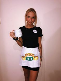 a woman holding a white frisbee in her right hand and wearing an apron