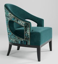 a green chair with an intricate design on the arm and back, sitting in front of a white background