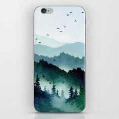 an iphone case with mountains and birds in the sky, on top of a white surface