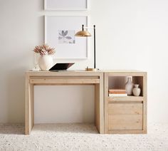 a desk with two drawers and a laptop on it in front of a white wall