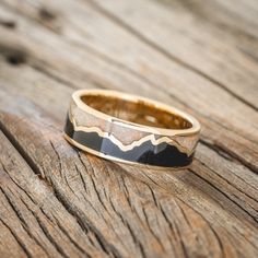 a gold and black ring sitting on top of a wooden table