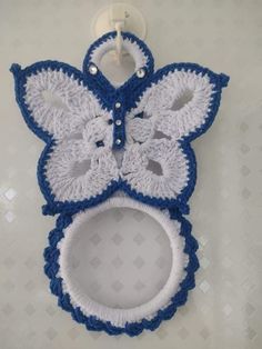 a blue and white crocheted mirror hanging on a wall