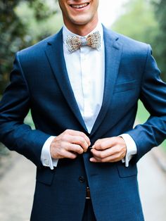 a man wearing a blue suit and bow tie