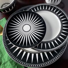 black and white plates stacked on top of each other with forks in front of them