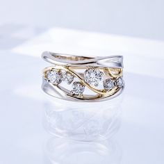 two tone gold and silver ring with diamonds on white surface, close up view from the side