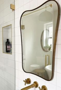 a bathroom with a sink, mirror and toilet paper dispenser on the wall