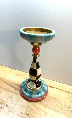 a colorful vase sitting on top of a wooden table