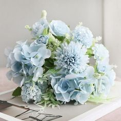 a bouquet of blue flowers sitting on top of a wooden table next to a pair of scissors