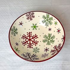 a bowl with snowflakes on it sitting on a white tableclothed surface