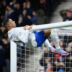 a soccer player is diving into the net