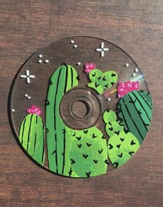 a cd that has been decorated with green and pink cactuses on the disc cover