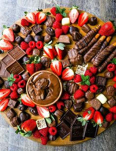 a platter filled with assorted chocolates, strawberries, and other foods