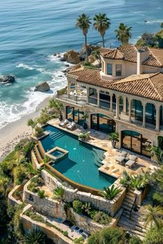 an aerial view of a house with a pool and beach in the foreground, surrounded by palm trees