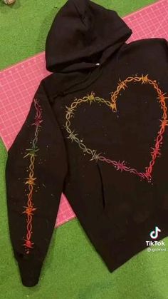 a black hoodie with a heart drawn on it