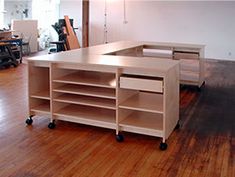 an empty room with wooden floors and shelves on the floor in front of a desk