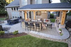 an outdoor kitchen and dining area in a backyard