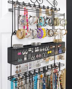 a wall mounted jewelry rack with lots of earrings on it