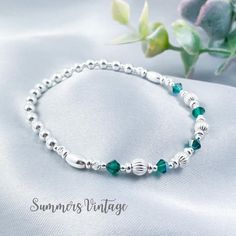 This dainty solid .925 sterling silver bracelet featuring Swarovski Emerald crystals makes the ideal gift for those who celebrate their birthday in May  May is represented in the Swarovski birthstone chart as an Emerald, a deep rich green crystal that symbolizes love, wealth, and happiness  The eclectic mix of sterling silver beads are strung on high quality, strong, professional jewellers' elastic meaning there are no fiddly clasps to deal with, simply roll the bracelet over your hand, and onto your wrist The bracelet comes presented in a beautiful grey faux suede jewellery pouch along with aftercare instructions and a cleaning cloth ☽ SIZE: Available in wrist sizes: Small (17cm), Medium (18cm) or Large (19cm) If you're unsure about sizing please drop me a message and I'll be more than ha Elegant Personalized Sterling Silver Beaded Bracelets, Anniversary Green Sterling Silver Bracelets, Silver Classic Crystal Bracelet As Gift, Classic Silver Crystal Bracelet As Gift, Classic Silver Crystal Bracelet Gift, Silver Spiritual Bracelets For Anniversary, Sterling Silver Bracelets For May Birthstone Anniversary, Classic Sterling Silver Beaded Bracelet For Gifts, Dainty Nickel-free Beaded Bracelets Gift