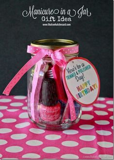 a jar filled with lots of different items on top of a pink and white table cloth