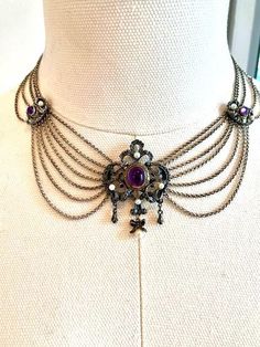 Vintage Necklace Victorian style Sterling Silver with Purple Amethyst cabs.  This necklace is from the 1970's. It was never worn. Approx 16.5 inches long. 7 chains towards the front 5 on sides and 3 towards back. Beautiful silver work on front with dangles with the Amethyst and pearls. Two sterling side bars also with amethyst and pearls and back clasp has an amethyst cab also. This is a darker color silver made that way to highlight the design.  There is alot of work in this necklace and design. Hangs very nice on the neck. Comes with matching pair of Earrings. These are clip on, one is missing the back clip.  These came from the oldest jewelry shop still in existence in Augsburg, Germany.  If you have any questions, let me know will be mailed with insurance Vintage Necklace Victorian, Augsburg Germany, Female Jewelry, Purple Jewelry, Diy Wire Jewelry, Funky Jewelry, Silver Work, Chatelaine, Old Jewelry