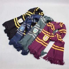 several harry potter scarves laid out on a white surface with one scarf folded over the other